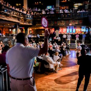 Bidder raising paddle during auction at Bid for Brotherhood