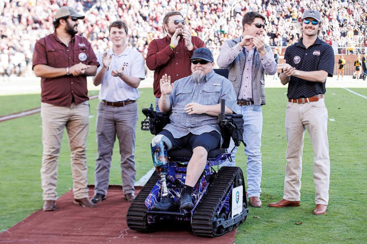 Mississippi State KA brothers on football field with Army Sergeant Jeff Hemenger