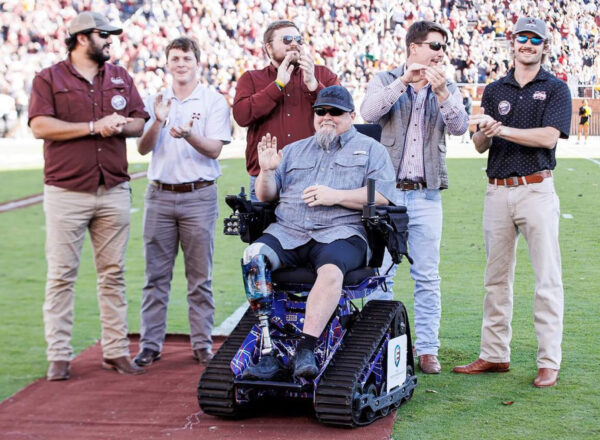 Mississippi State KA brothers on football field with Army Sergeant Jeff Hemenger