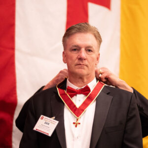 Former Knight Commander Duncan placing jewel on Dan McAfee