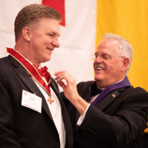 Former Knight Commander Duncan placing jewel on Dan McAfee