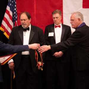 Former Knight Commander Duncan placing jewel on Dan McAfee