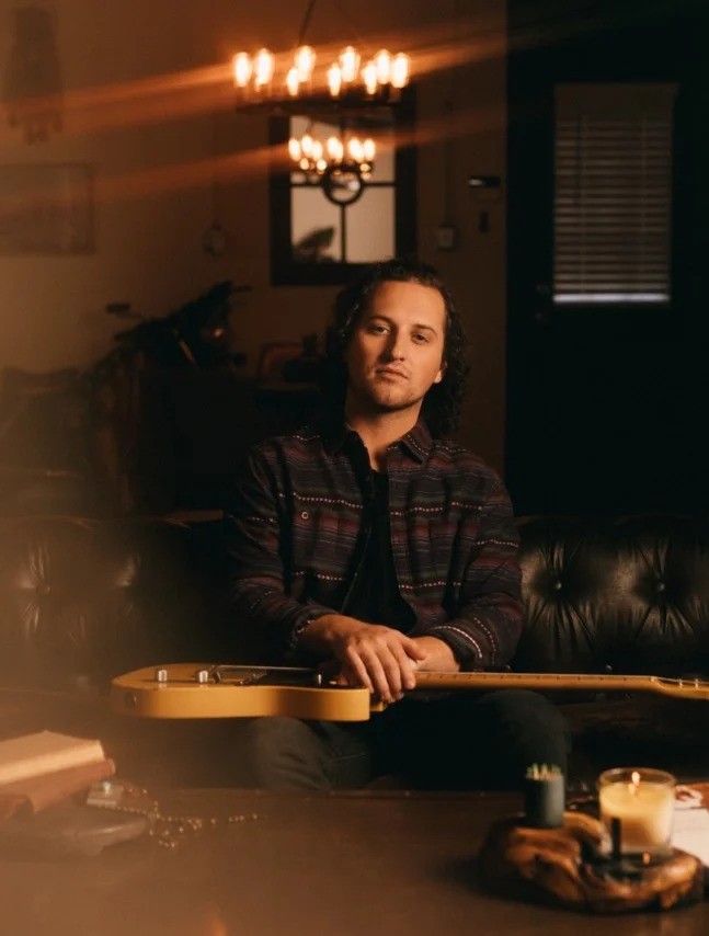 Reid with guitar on lap