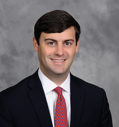 headshot of man in suit and tie