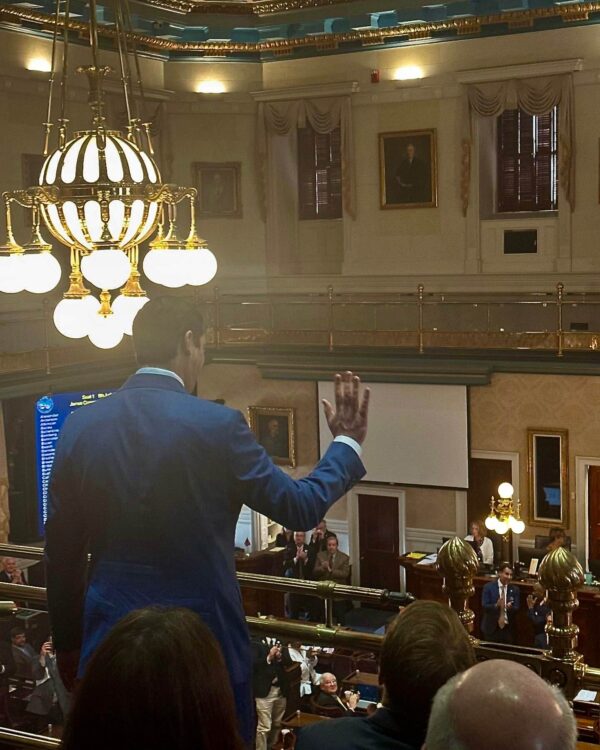 man in suit being applauded by others