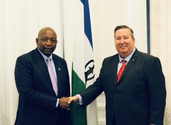 two men in suits and ties shaking hands
