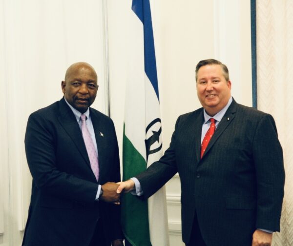 two men in suits and ties shaking hands
