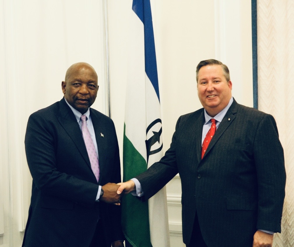 two men in suits and ties shaking hands