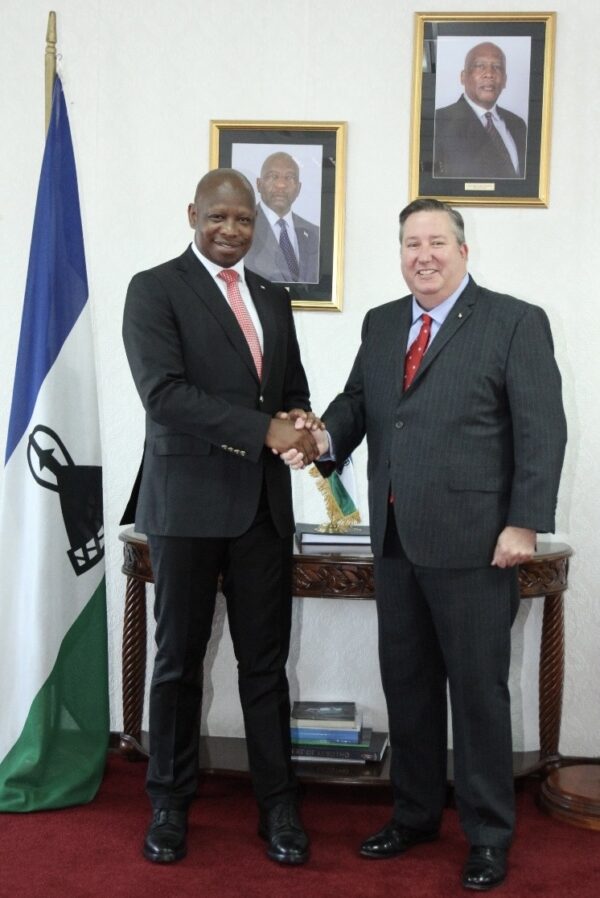 two men in suits and ties shaking hands
