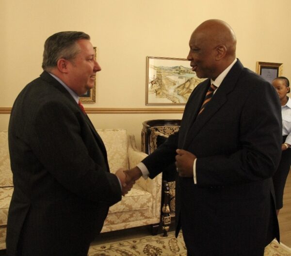 two men in suits and ties shaking hands