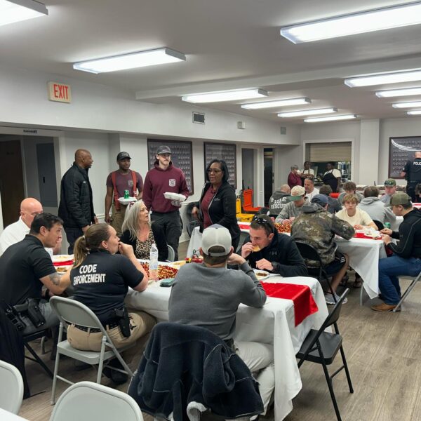 police and fire fighters eating at table with KA brothers
