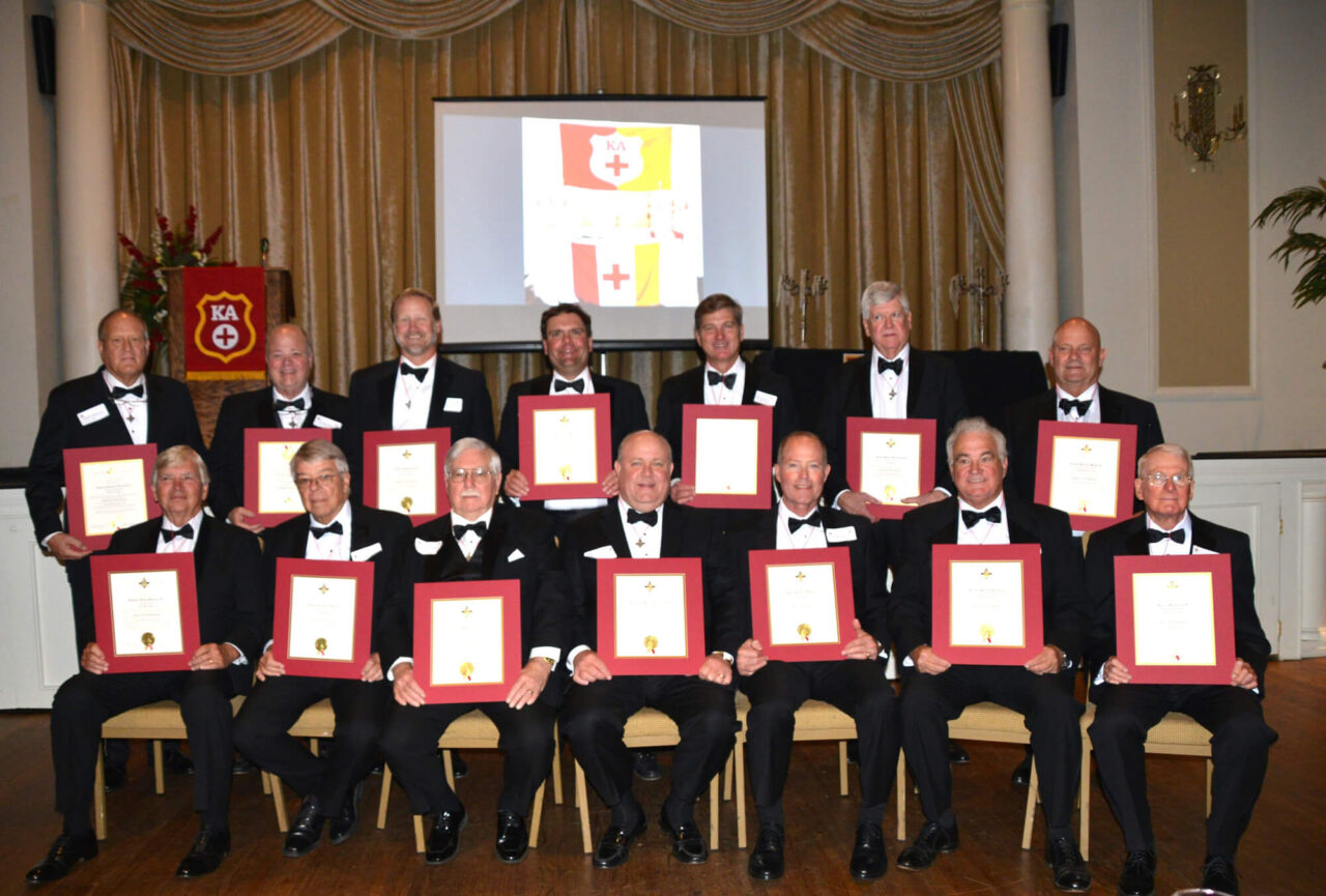 group of men in tuxes holding certificates