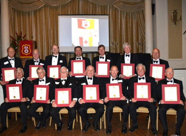 group of men in tuxes holding certificates
