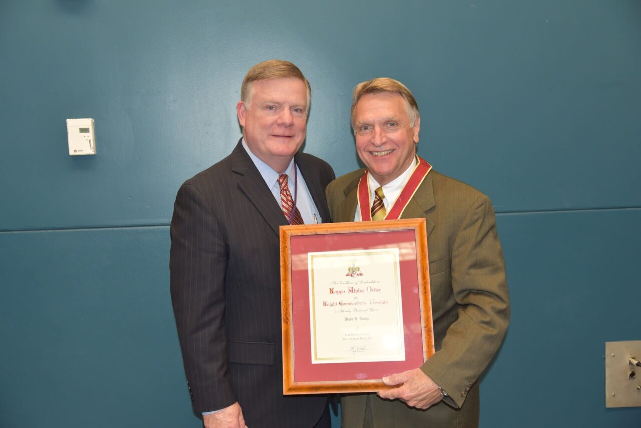 two men in suits holding award