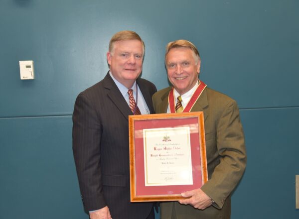 two men in suits holding award