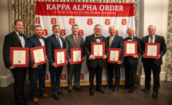 men in tuxes holding certificates