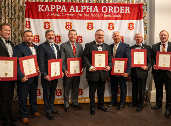 men in tuxes holding certificates
