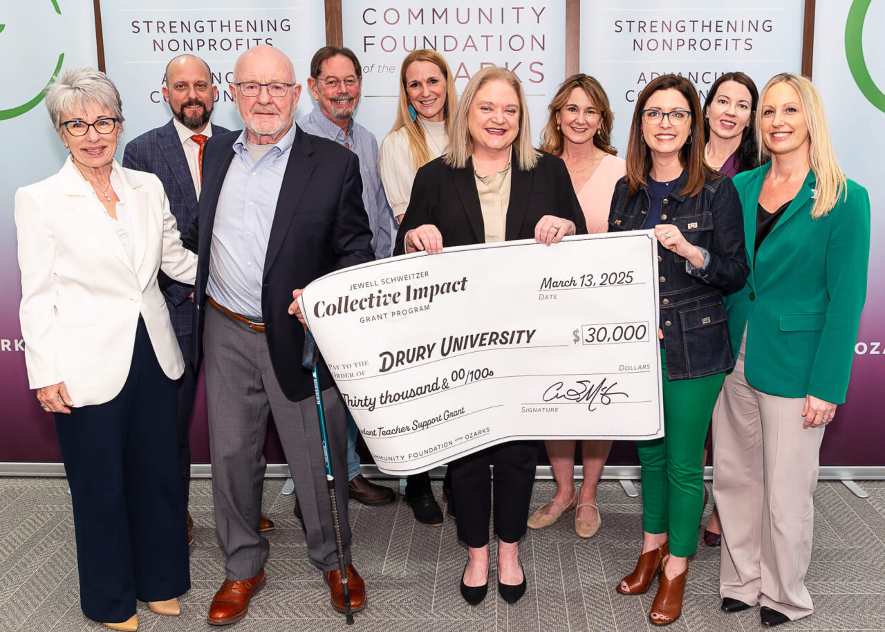 group of people holding large check