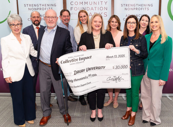 group of people holding large check