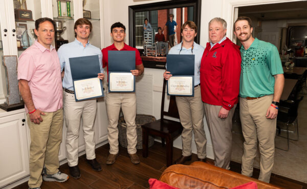 six men casually dressed, three with certificates