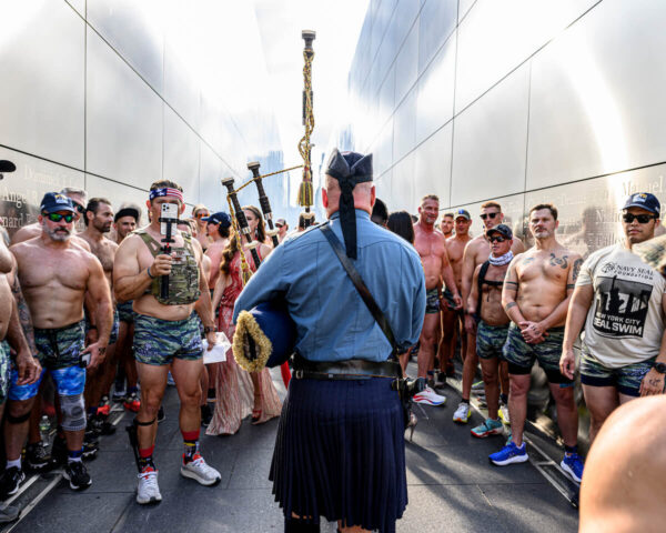 man playing bagpipes with Navy SEALs watching