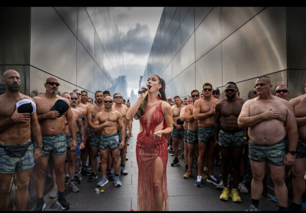 woman in dress singing U.S. national anthem with men holding hands over hearts