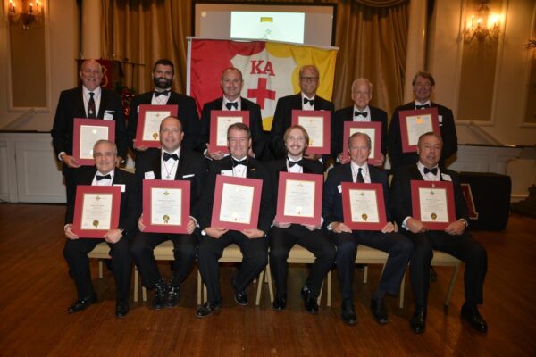 men in tuxes holding certificates