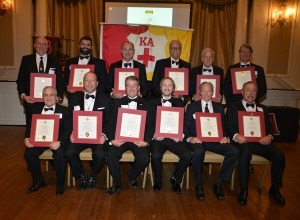 men in tuxes holding certificates