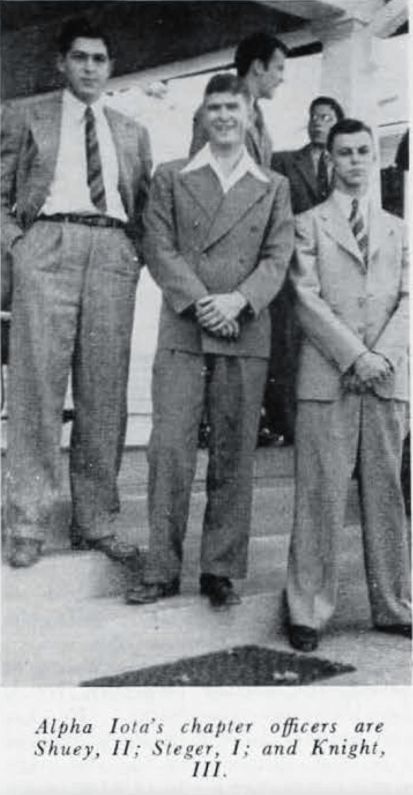 black and white photo of three men in suits on steps of house